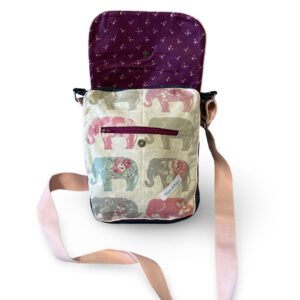 Sac bandoulière ouvert montrant un motif d’éléphants colorés sous le rabat fleuri violet
